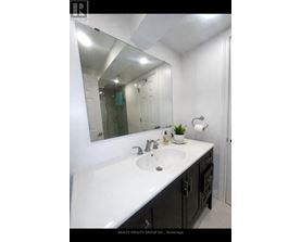 A bathroom with a white sink and a mirror.
