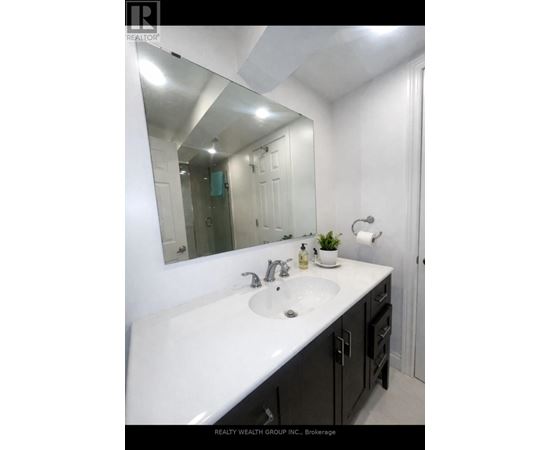 A bathroom with a white sink and a mirror.