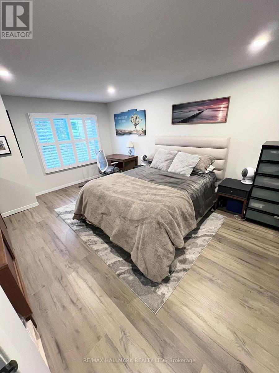A bedroom with a large bed and a painting on the wall.