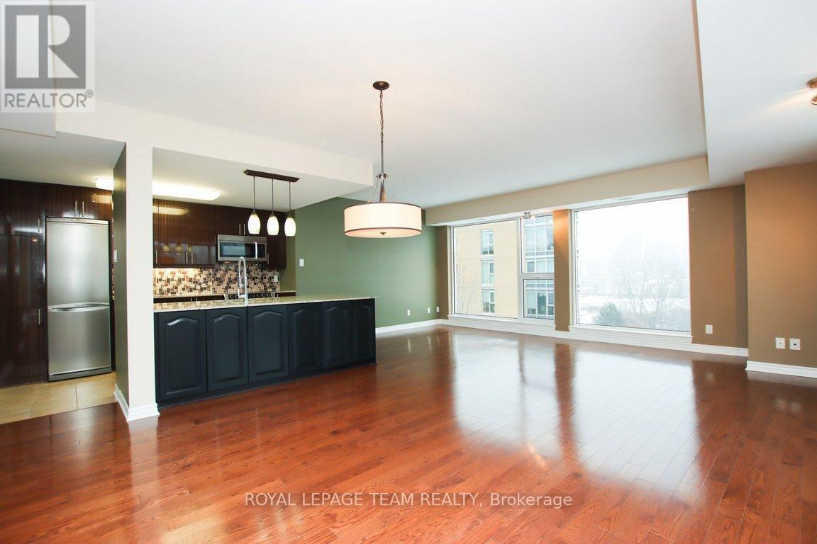 A spacious room with wooden floors and a large window.