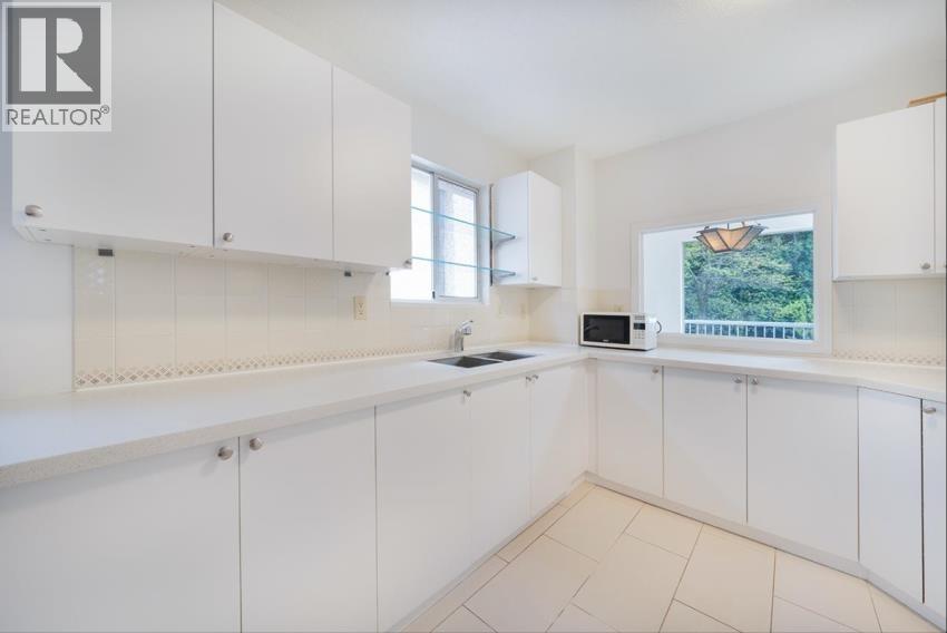 A white kitchen with a microwave and oven built in.