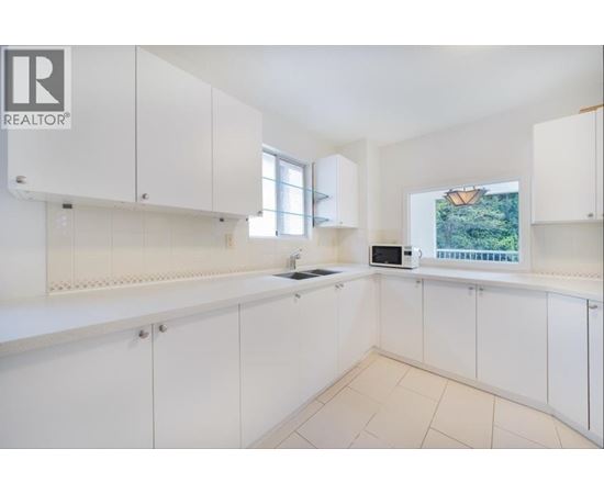 A white kitchen with a microwave and oven built in.