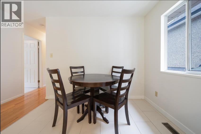A dining room with a table and chairs.