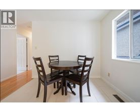 A dining room with a table and chairs.