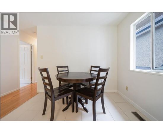 A dining room with a table and chairs.