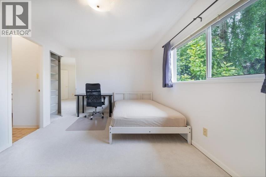 A bedroom with a bed, desk, and chair.
