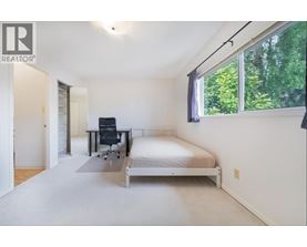 A bedroom with a bed, desk, and chair.