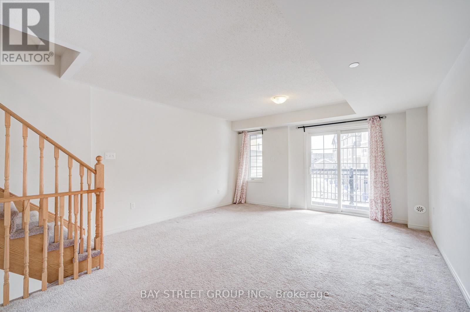 A spacious bedroom with a large bed and a window with curtains.