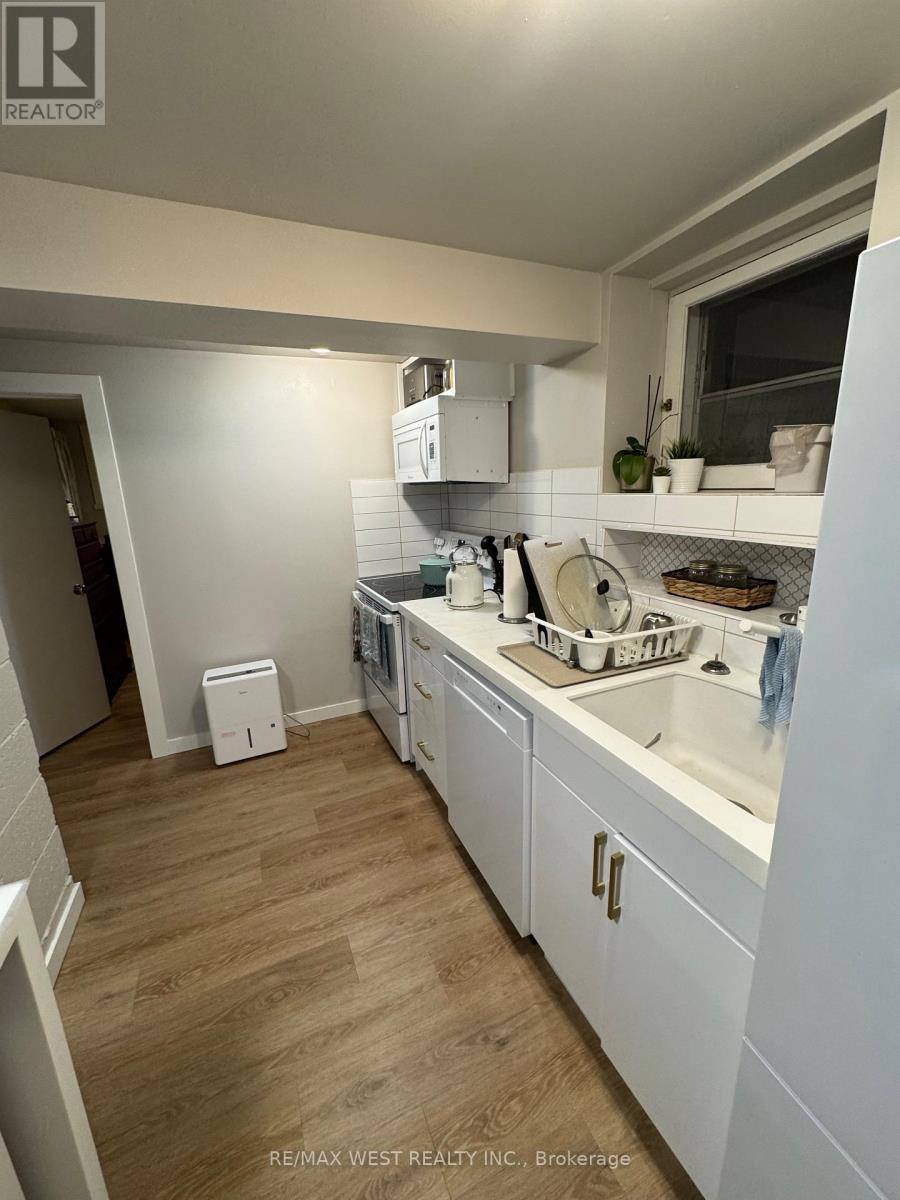 A kitchen with white cabinets and a wooden floor.