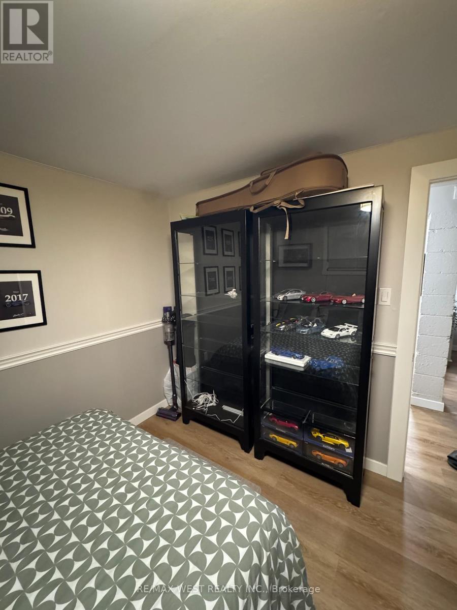 A bedroom with a bed and a black cabinet with a shoe rack.