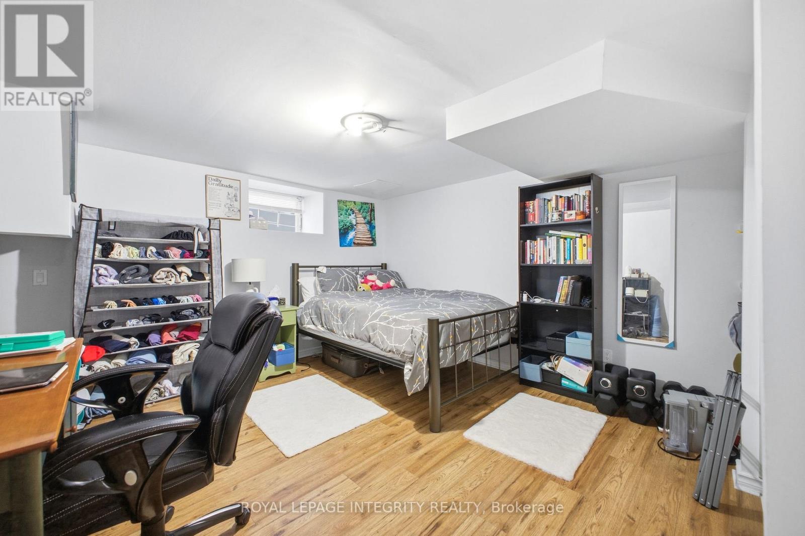 A bedroom with a bed, desk, and bookshelf.