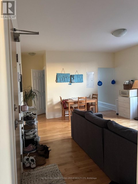 A living room with a grey couch and a dining table.