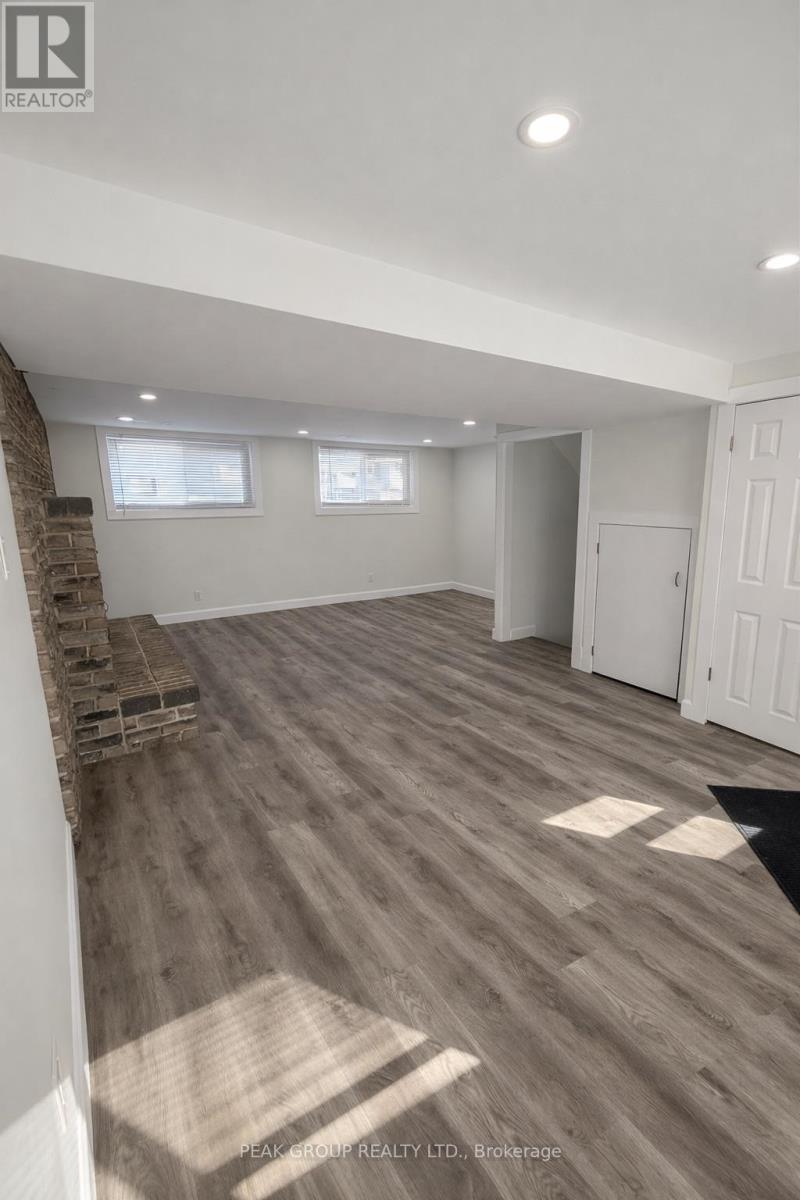 A spacious room with wooden flooring and white walls.