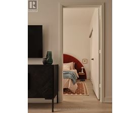 A bedroom with a bed, a chair, and a television.