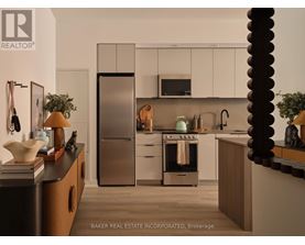 A modern kitchen with a refrigerator, oven, and microwave.