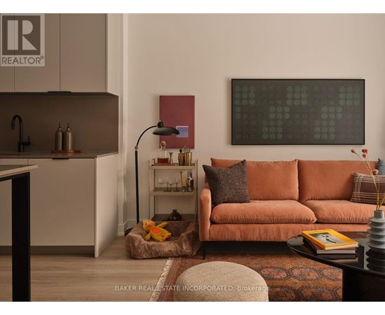 A living room with a brown couch and a painting on the wall.