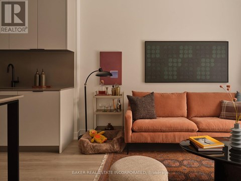 A living room with a brown couch and a painting on the wall.