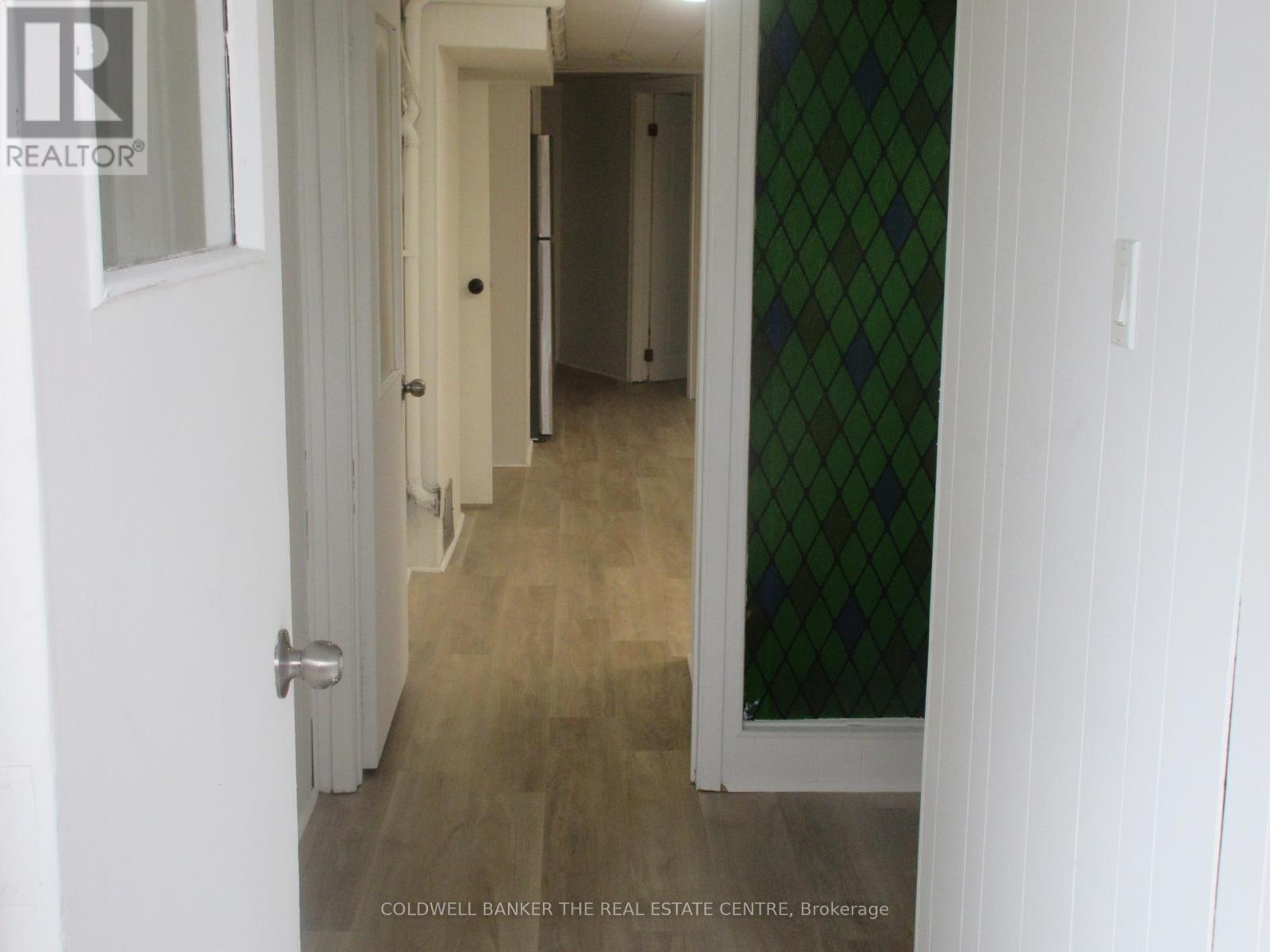 A hallway with a white door and a green diamond patterned wall.