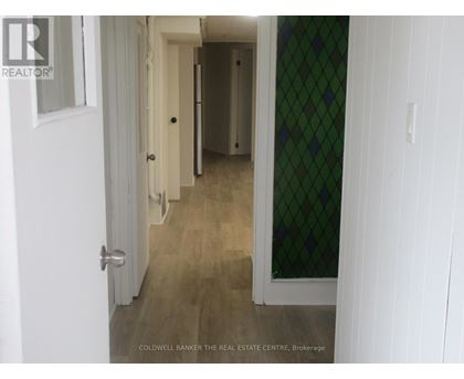 A hallway with a white door and a green diamond patterned wall.