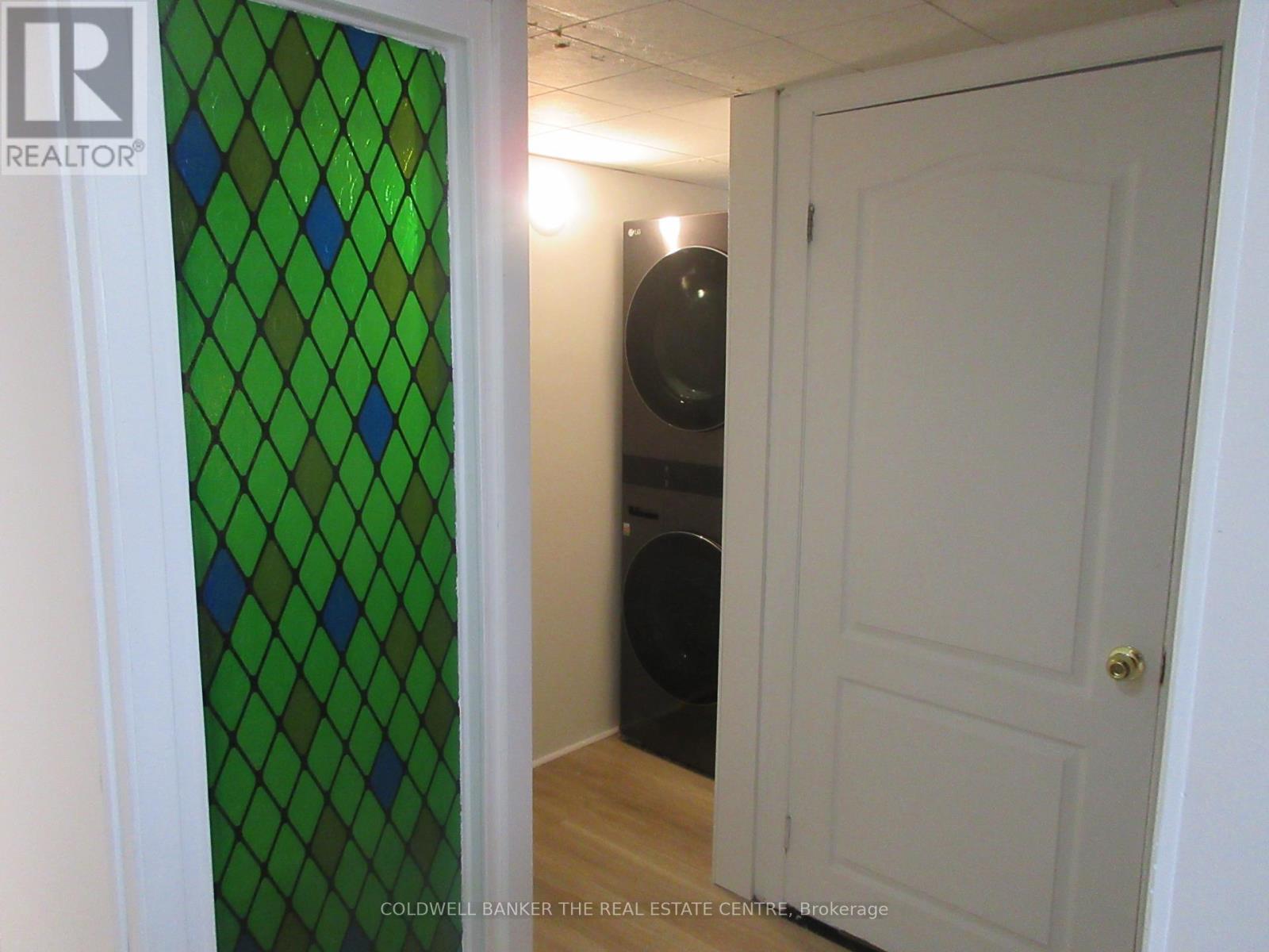 A room with a green diamond patterned glass door and a white door.
