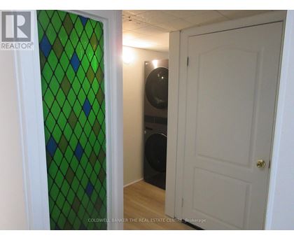 A room with a green diamond patterned glass door and a white door.
