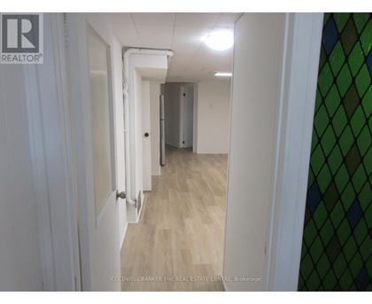 A hallway with white walls and a wooden floor.