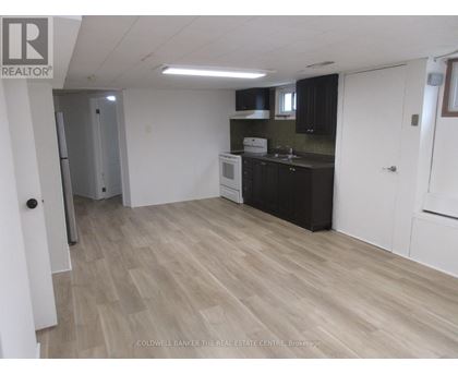 A kitchen with black cabinets and a white fridge.
