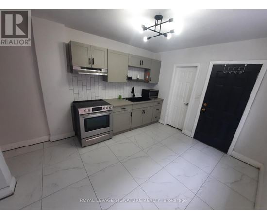 A kitchen with a stove top oven, microwave, and a refrigerator.