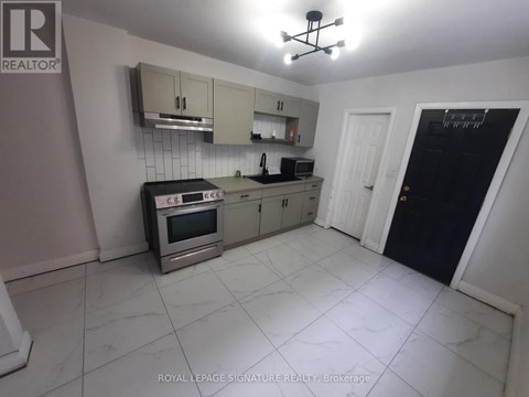 A kitchen with a stove top oven, microwave, and a refrigerator.