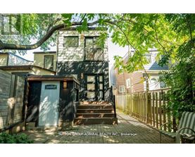 A tree branch is in the foreground of a photo showing a house and a sign that says Sutton Group Admiral Realty Inc Brokerage.