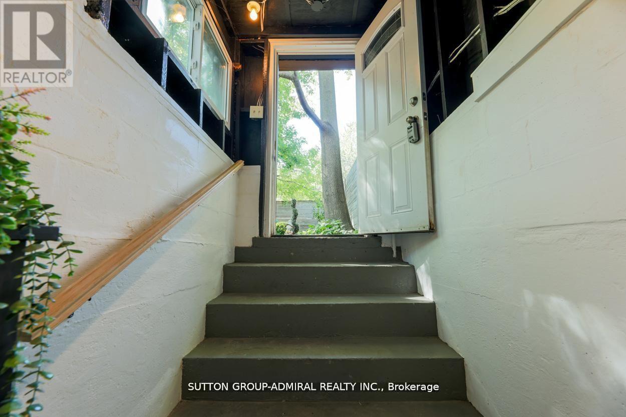 A staircase with a sign that says Sutton Group-Admiral Realty Inc., Brokerage.