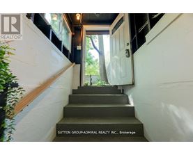 A staircase with a sign that says Sutton Group-Admiral Realty Inc., Brokerage.