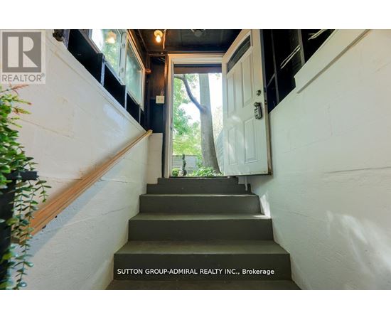 A staircase with a sign that says Sutton Group-Admiral Realty Inc., Brokerage.