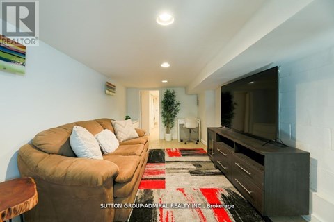 A living room with a brown couch and a flat screen TV.