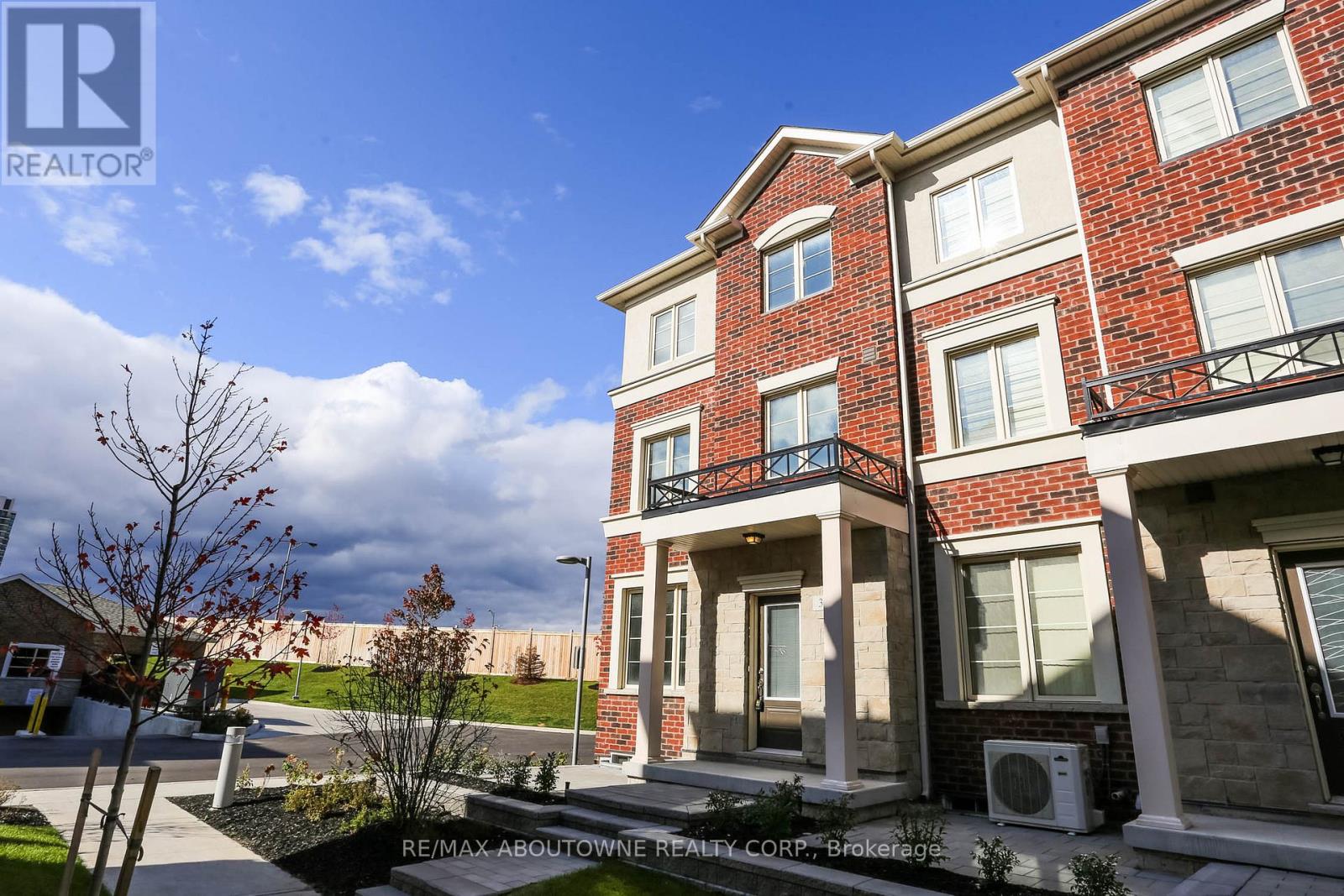 A red brick apartment building with a balcony on the second floor.
