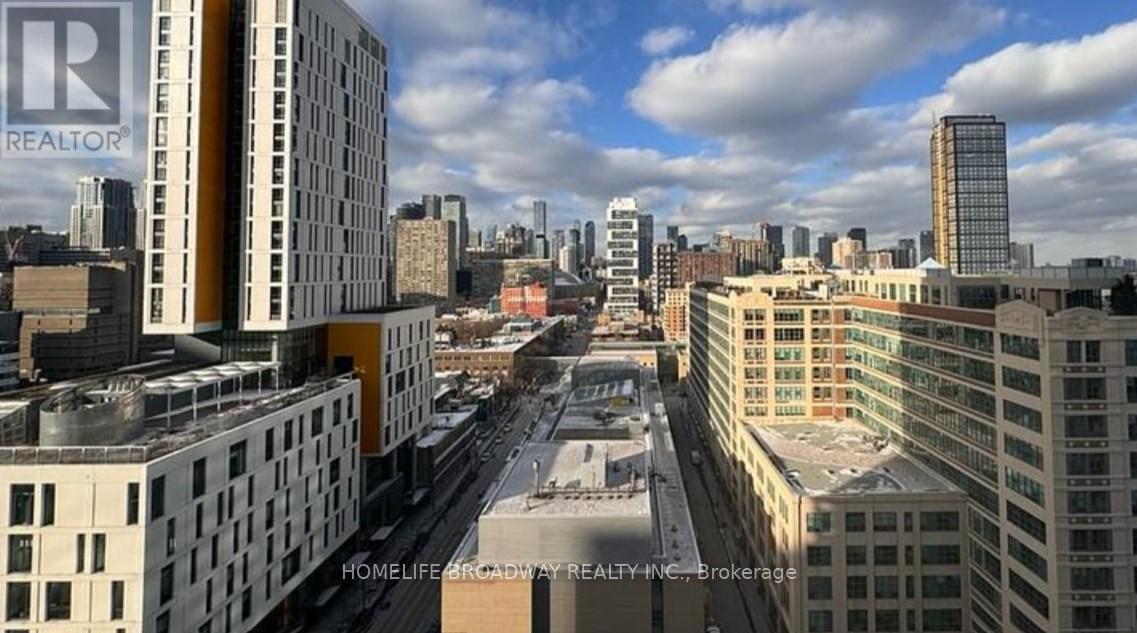A cityscape with buildings and a cloudy sky.