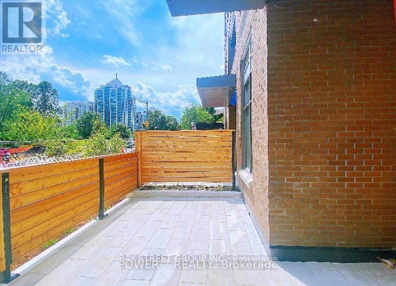 A backyard with a wooden fence and a brick building.