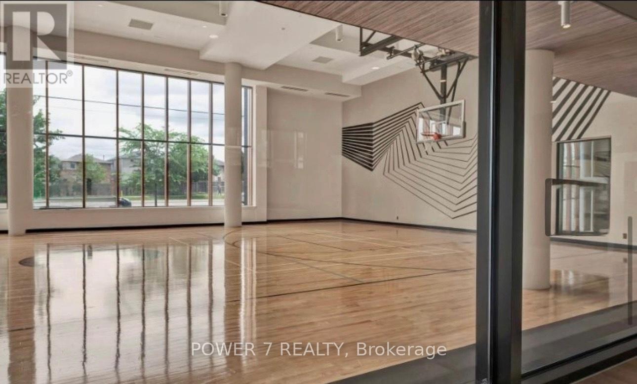 A spacious room with wooden floors and a basketball hoop on the wall.