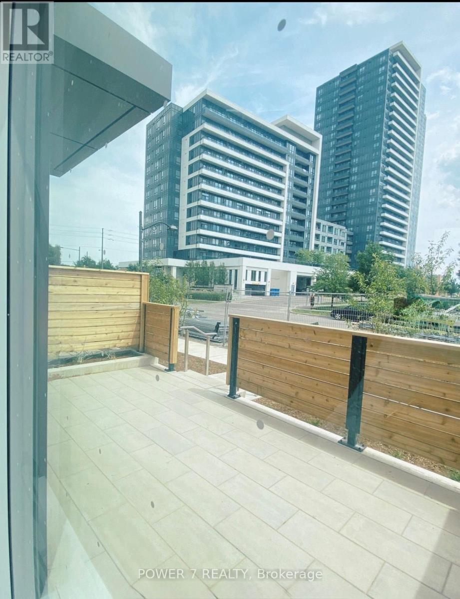A balcony with a glass railing overlooks a cityscape.