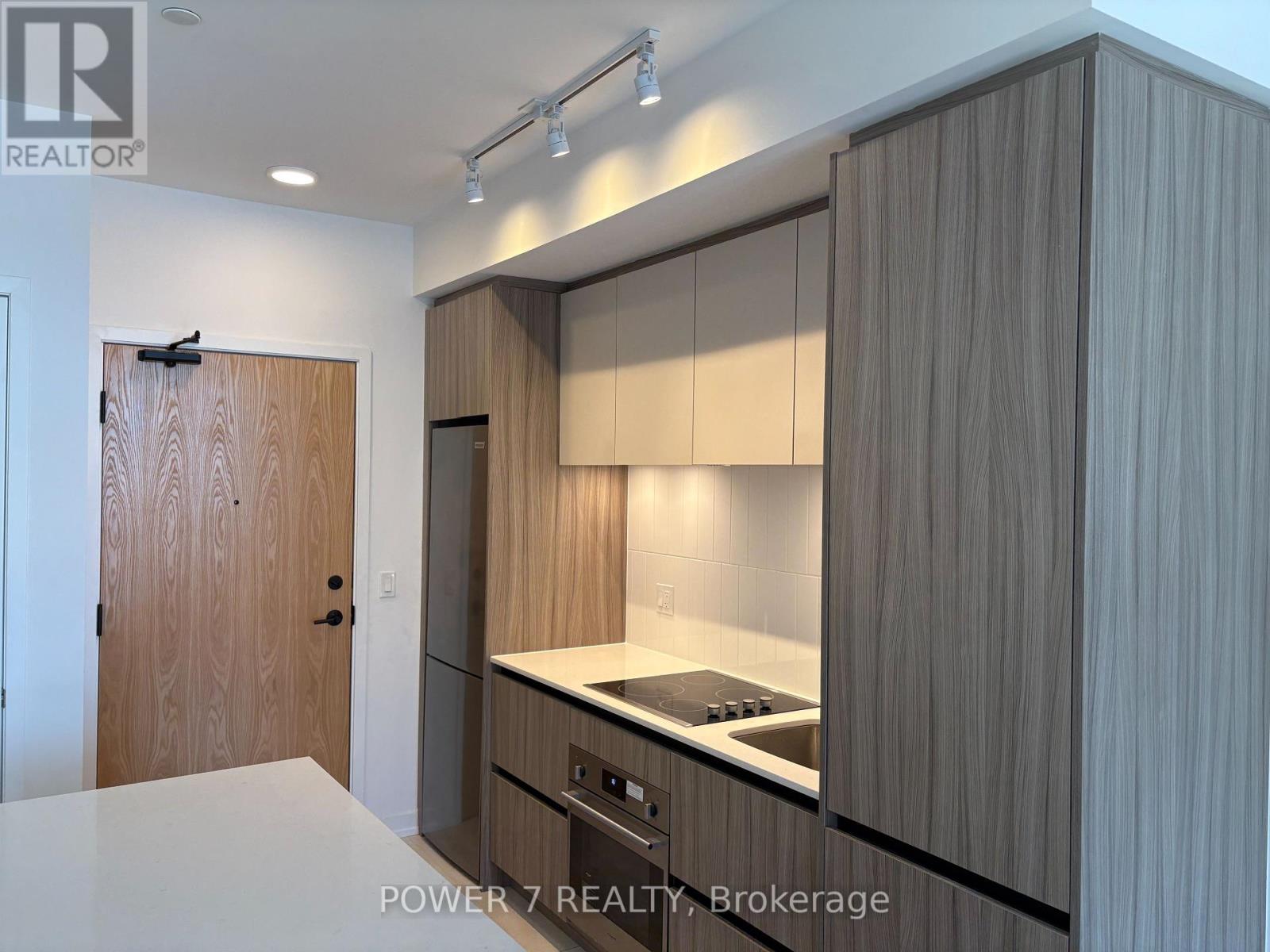 A modern kitchen with wooden cabinets and a white countertop.