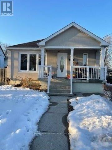 A small house with a porch and a snow-covered ground.