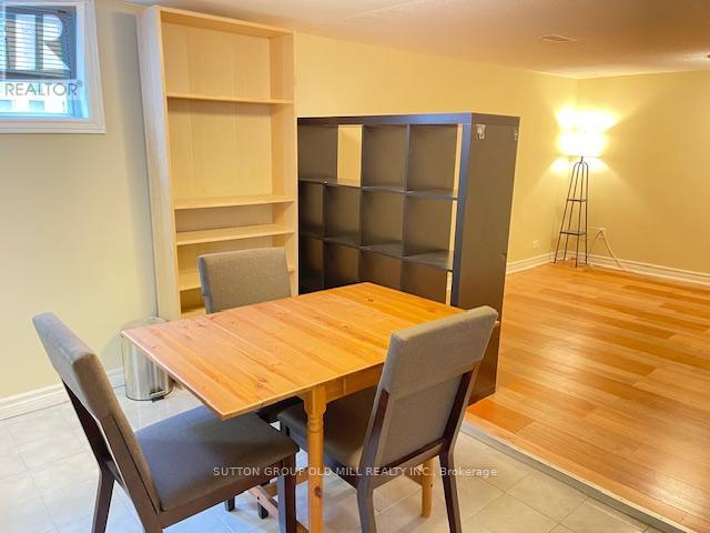 A dining room with a wooden table and chairs.
