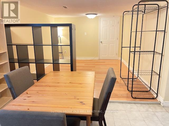 A room with a wooden table and chairs and a bunk bed.