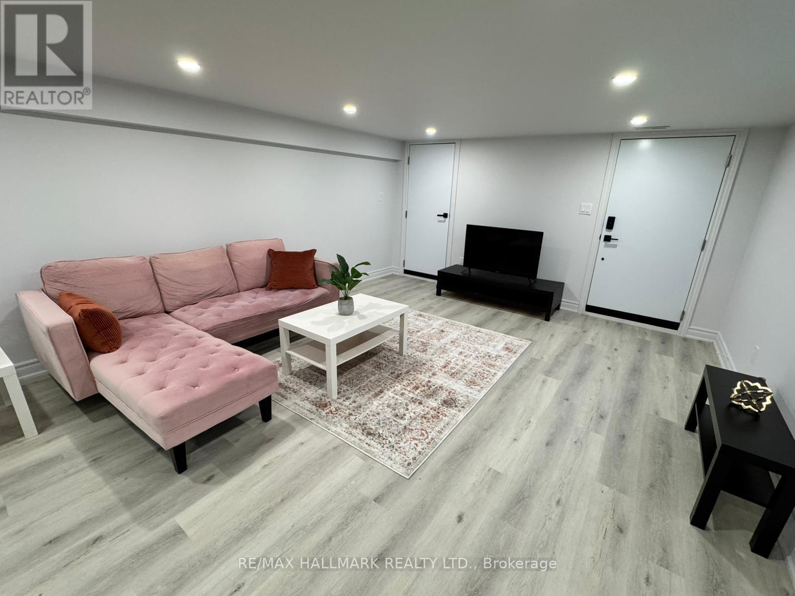 A living room with a pink couch and a white coffee table.