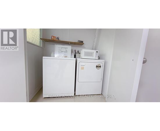 A white fridge and freezer in a small room.