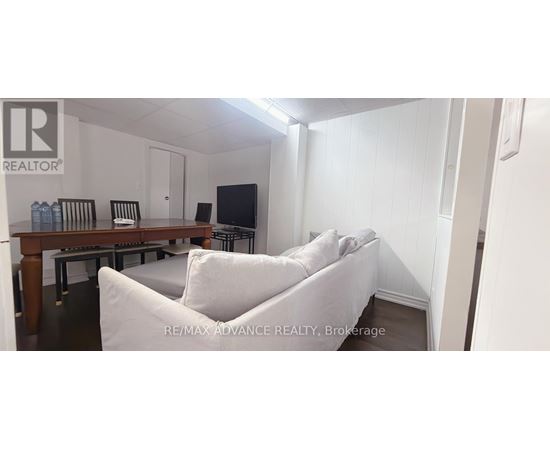 A living room with a white couch and a wooden table.