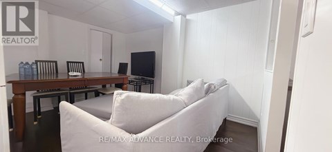 A living room with a white couch and a wooden table.