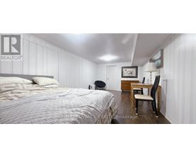 A bedroom with a bed, desk, and chair.