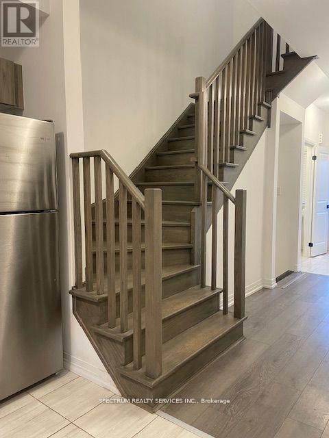 A staircase with wooden steps and handrails is in a modern home.