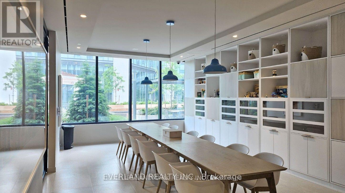 A conference room with a long table and chairs, and a row of shelves with various items on them.